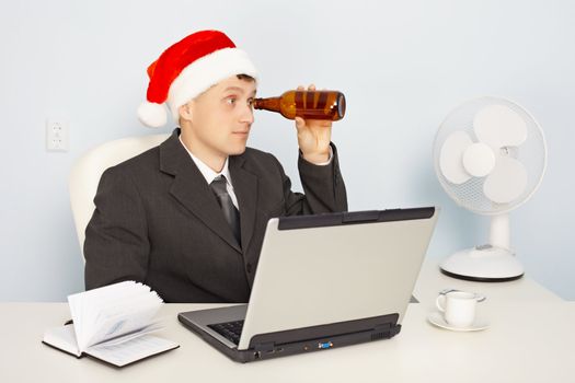 Funny man in the New Year's hat looks to the future through a bottle