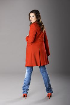 Beautiful fashion woman posing with a red coat
