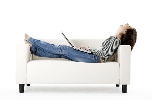 Beautiful woman on a white sofa with a laptop