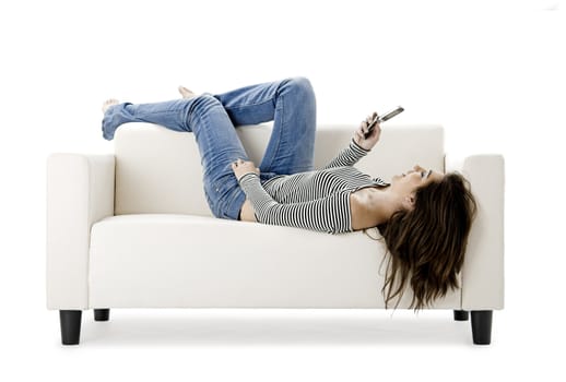 Beautiful happy woman on a white sofa making a phone call