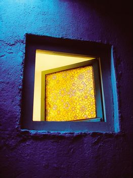yellow window on blue wall