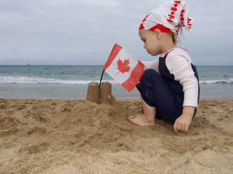 Cute girl is building a fort decorated with Canadian flag