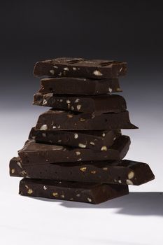 heap of broken black chocolate with nut 