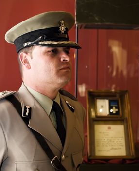 Man in military or police uniform in Malta with original George Cross medal in background