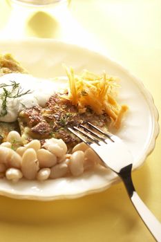 hot cake of cabbage with frigole and grated carrot over yellow background