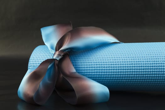 Blue yoga with a blue and brown ribbon on a black background is a sharing of yoga's pleasures