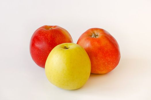 two red and one green apples on white background