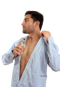 A young adult man spraying a perfume cologne aftershave onto skin before going out.  White background.