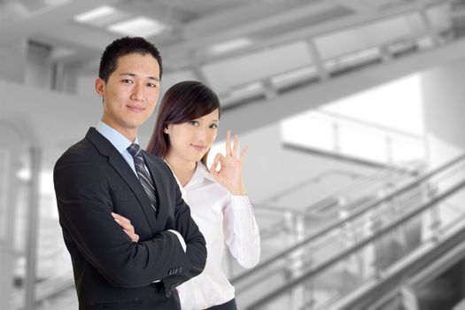 Business team, smiling businessman and friendly businesswoman in modern building.