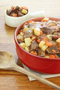 Crock pot full of fresh made roast beef with large chunks of beef, potatoes and carrots.