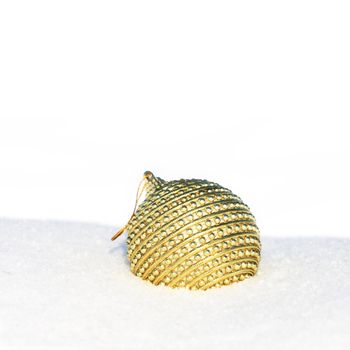 golden christmas bauble in snow