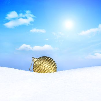 golden christmas bauble in snow