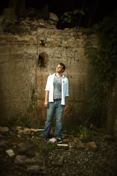 A man standing by an old wall