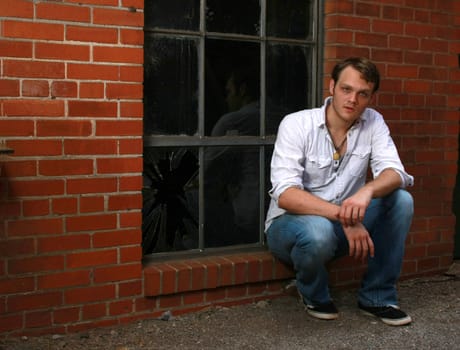 A man sitting on a ledge of a window