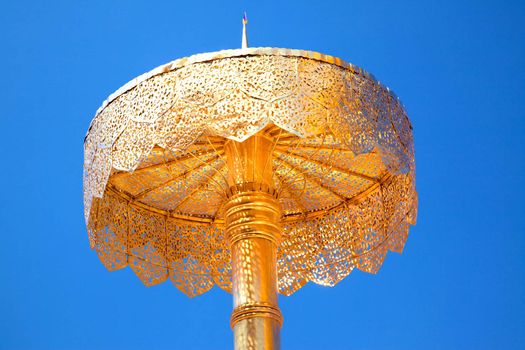 Golden Shield or religious object against a blue sky
