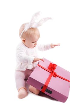 Baby in rabbit costume with pink gift over white