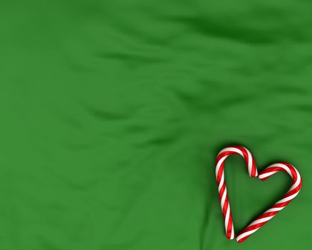Heart made from christmas candies on green fabric background