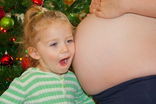 A child listening to Mommy's little Christmas present!