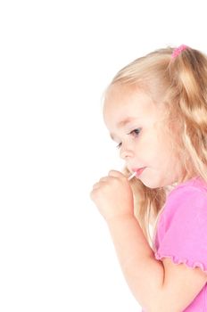 Little cute girl in pink and with ponytails in studio