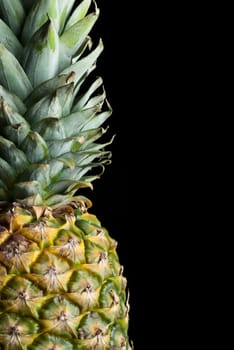Detail of a fresh juicy pineapple isolated on black