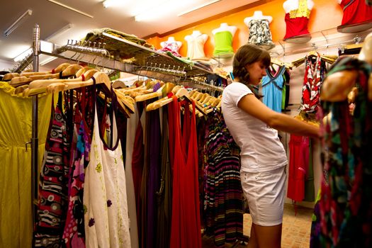 Woman choosing  a dress in a female shop