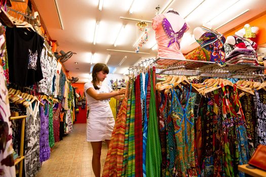Woman choosing  a dress in a female shop