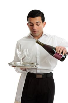 A waiter, servant or bartender serving alcohol wine from a bottle into wine glasses.