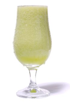 Close view of a fresh curved glass of homemade cantaloupe juice isolated on a white background.