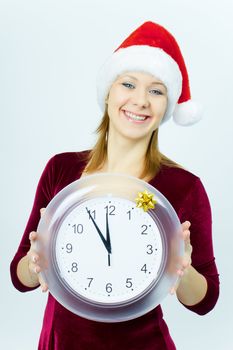 smiling girl in a Santa hat and with the clock. New Year's Eve