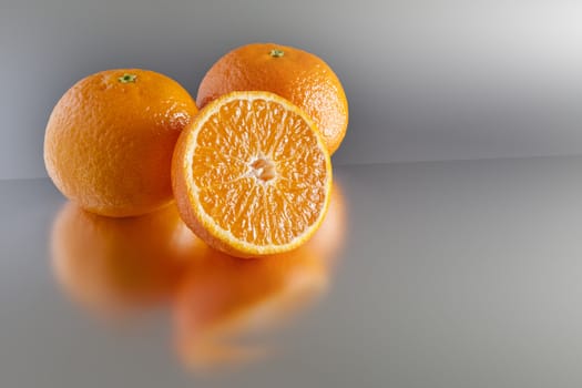 An image of three clementines on grey