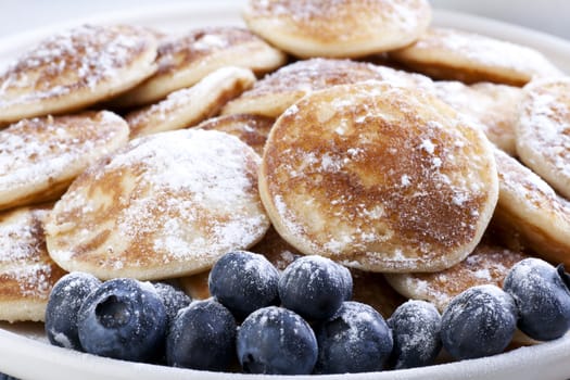 Dutch mini pancakes, or poffertjes, and fresh blueberries sprinkled with powdered sugar.