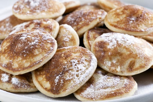 Dutch mini pancakes, or poffertjes, sprinkled with powdered sugar.