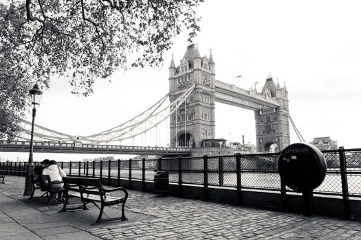 A black and white view of the famous Tower Bridge as seen from the London Tower bank