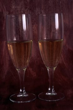 Two glasses of white wine isolated on painted background