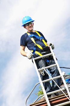 Construction worker standing on roof near ladder