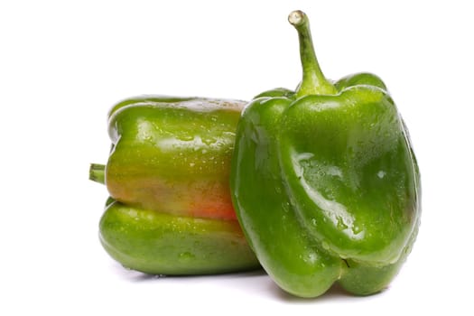 Close up view of two fresh green bell pepper isolated on a white background.