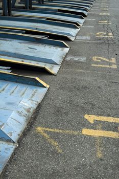 detail photo of empty steel parking slots, yellow numbers on ground, photo taken in new york