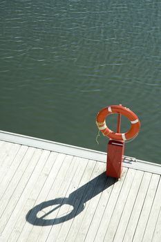 orange lifebuoy rescue ring on wooden pier