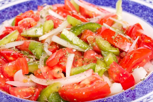 Close up view of some fresh ready made salad of tomato and green bell pepper.