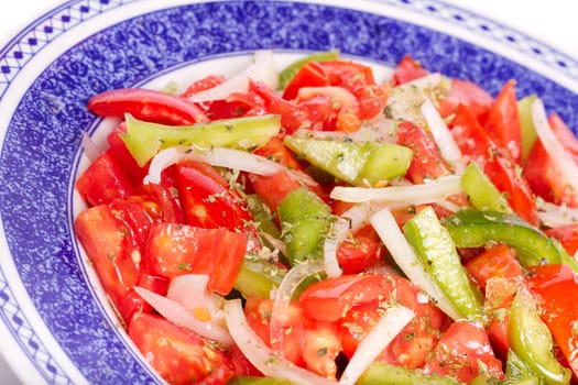 Close up view of some fresh ready made salad of tomato and green bell pepper.