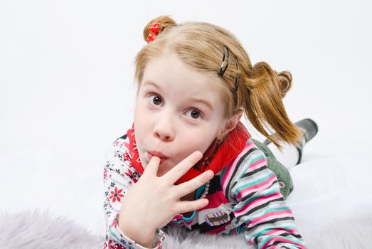 studio shot of pretty little girl lying on the floor