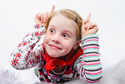 studio shot of pretty little girl with fingers like horns