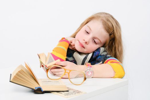 studio shot of pretty little girl reading a book