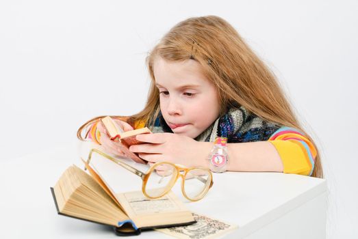 studio shot of pretty little girl reading a book