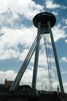 new bridge in bratislava dividing old center and petrzalka suburb, on top of the bridge is a restaurant, famous castle in background