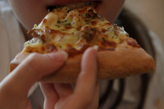 Close up of the person eating pizza.