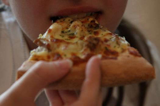 Close up of the person eating pizza.