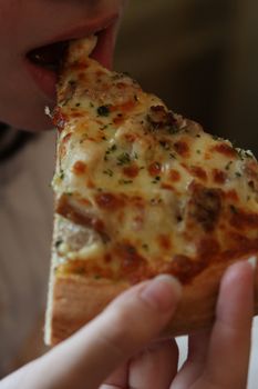 Close up of the person eating pizza.