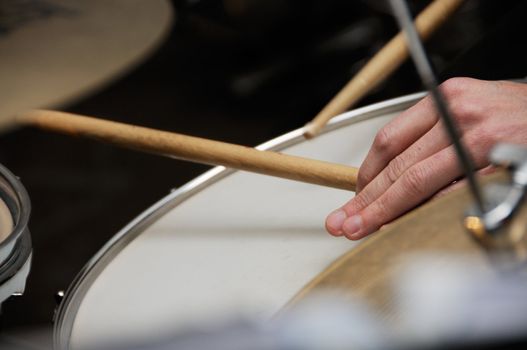 Closeup of drummer playing with his band on stage