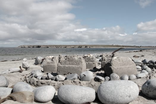 a sandcastle made with stones and sand on an irish shore